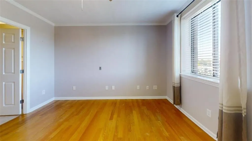 Unfurnished room with wood-type flooring and crown molding