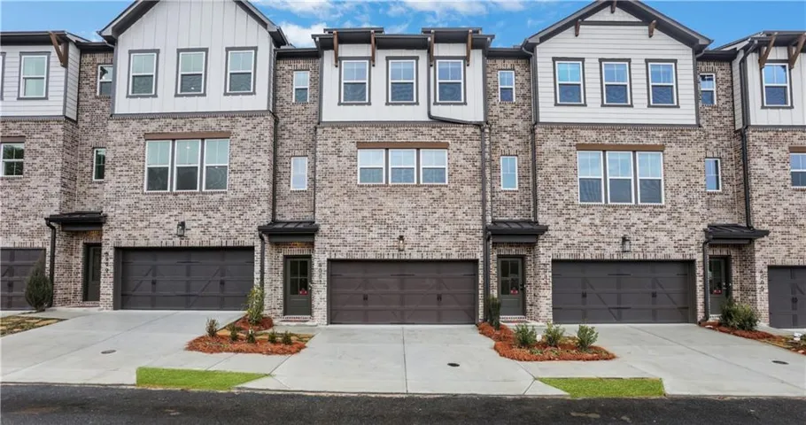 Brick exterior with gabled accents, multi-pane windows, and attached garages