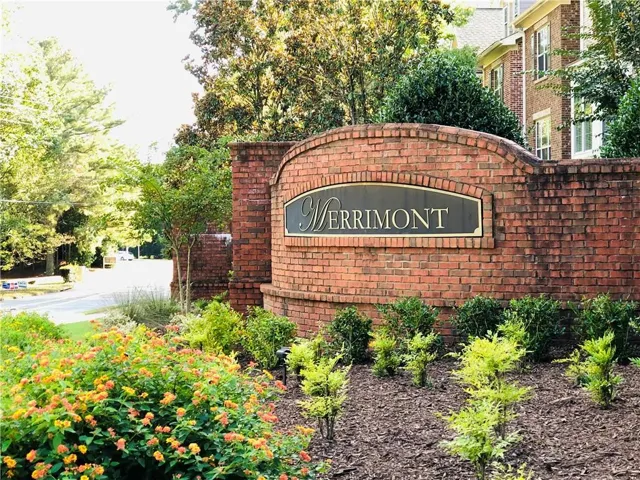 Brick entrance monument with an arched top, featuring an inset sign