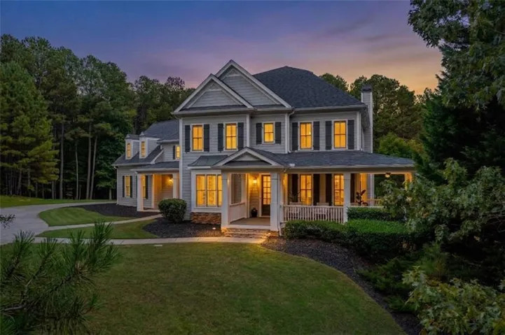 Two-story residence with a covered front porch featuring white railings