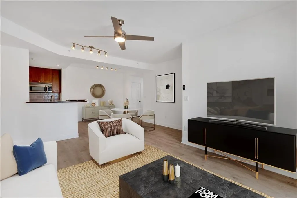 Living room featuring a ceiling fan, wood finished floors, and baseboards