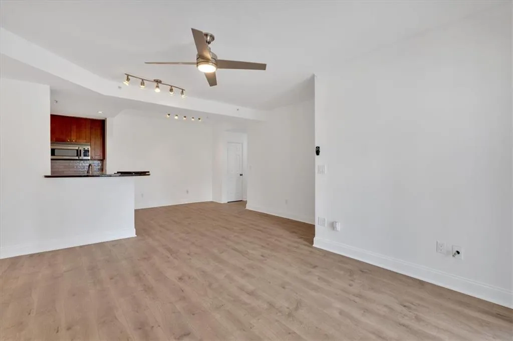 Unfurnished living room featuring ceiling fan, brand new quality LVP floors, and baseboards