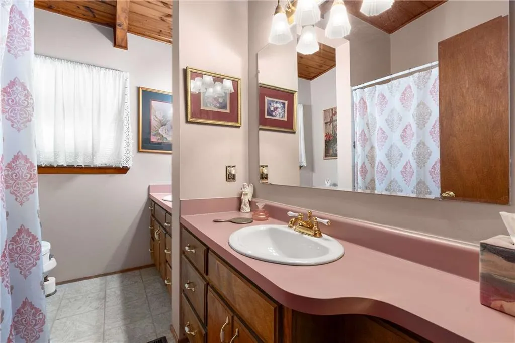 Full bathroom featuring vanity, a wooden ceiling with exposed beams, and tile patterned floors