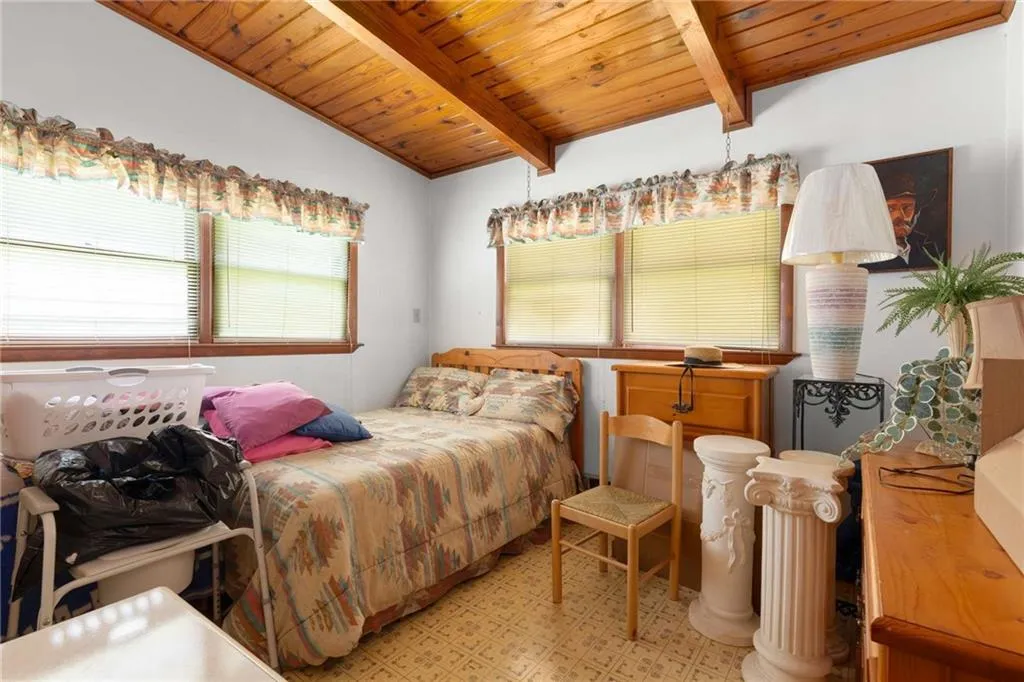 Bedroom with a wood ceiling with exposed beams