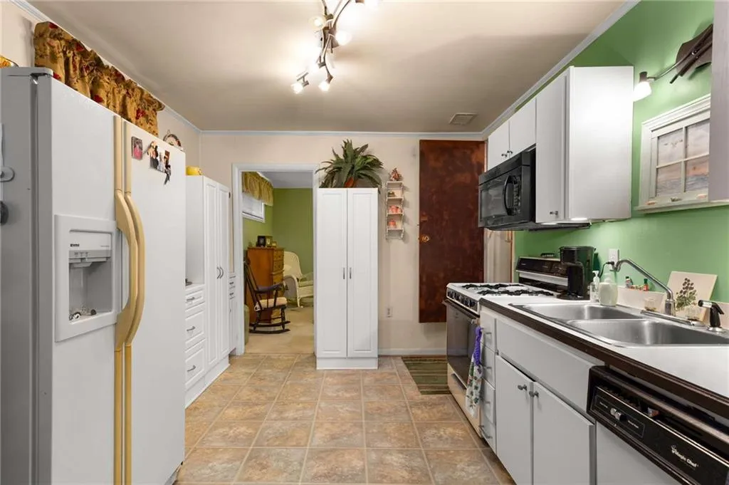 Kitchen featuring white appliances and white cabinets
