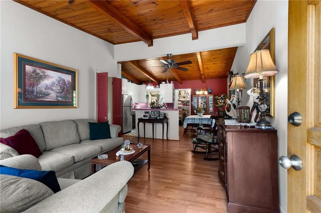 Living area featuring wooden ceiling, light wood-style floors, and ceiling fan