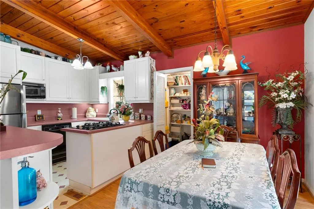 Dining space with a chandelier, a wooden ceiling with exposed beams, and light wood-style flooring