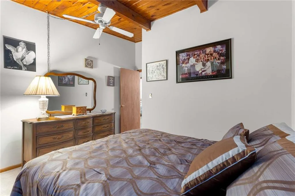 Bedroom with wood ceiling and a ceiling fan