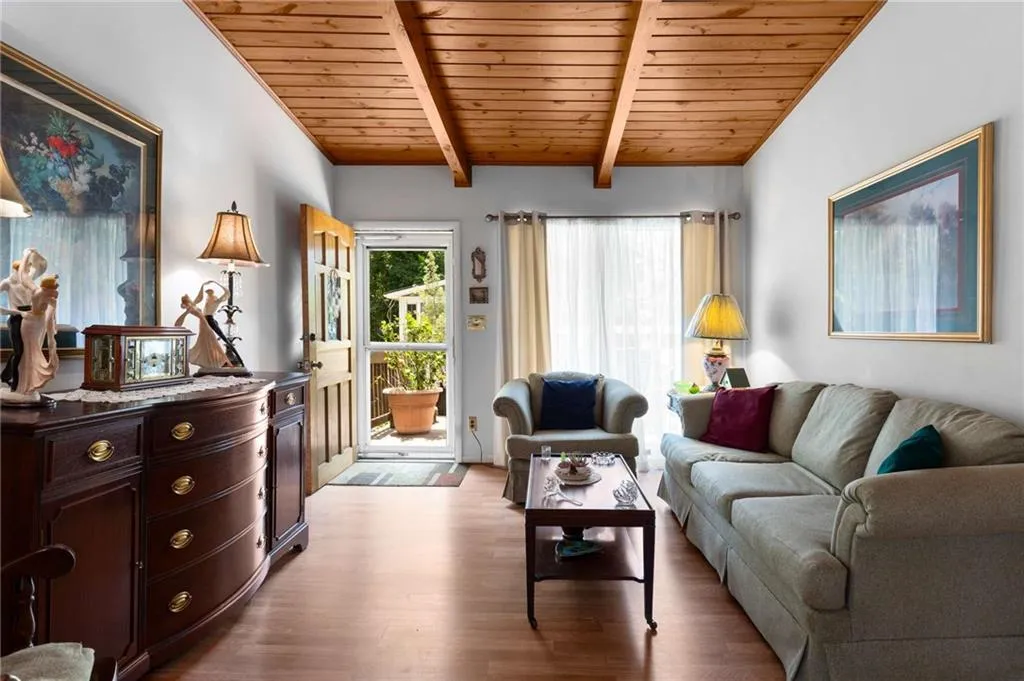 Living area featuring a wood ceiling with exposed beams and wood finished floors