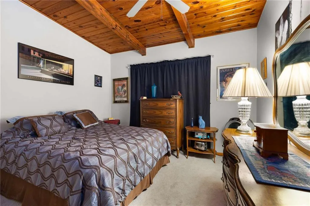 Carpeted bedroom featuring wooden ceiling