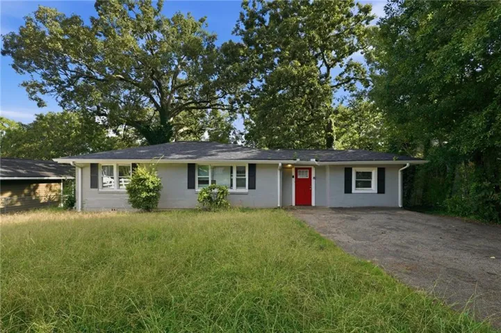 Single-story residence featuring a gray exterior, a red front door, and a dark shingle roof