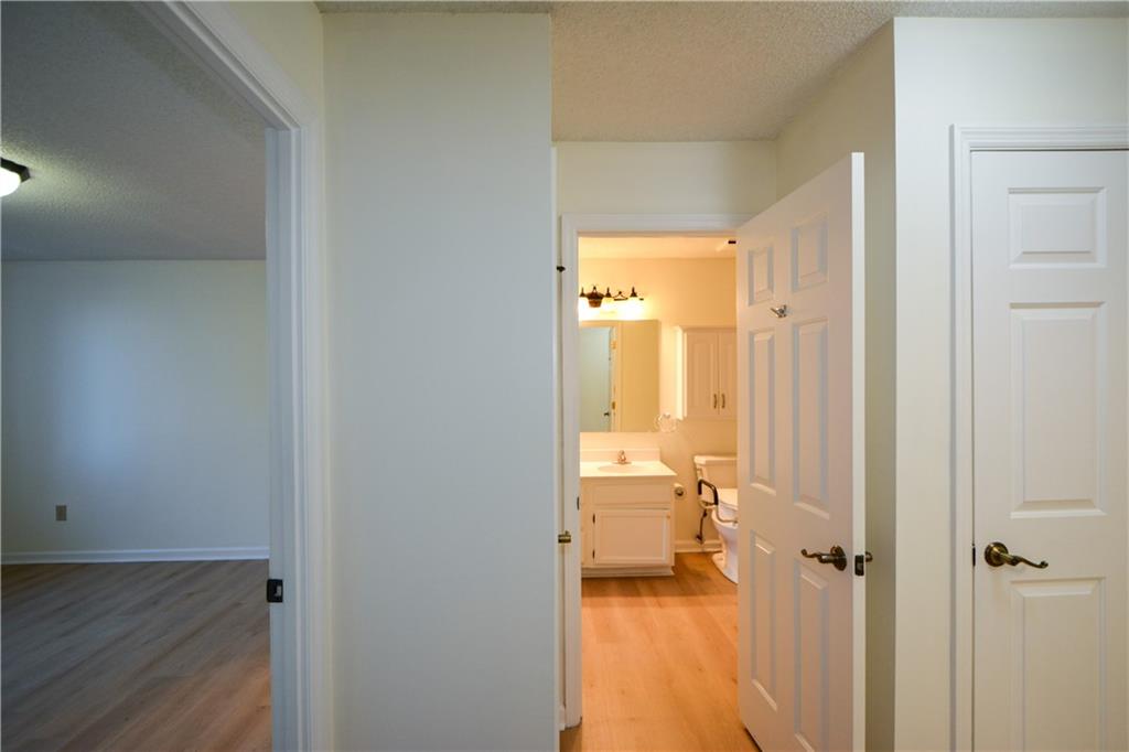 Hall with sink, a textured ceiling, and light hardwood / wood-style flooring