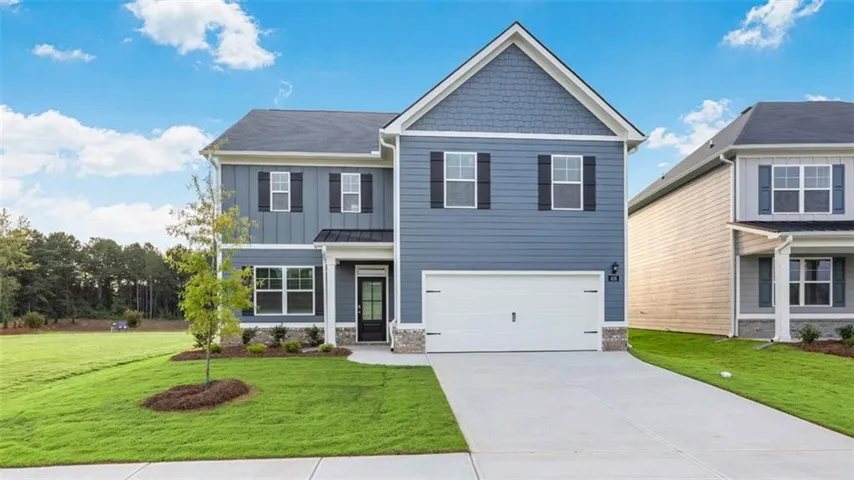 Two-story residence with a two-car garage, blue siding, stone accents, and a gabled roof