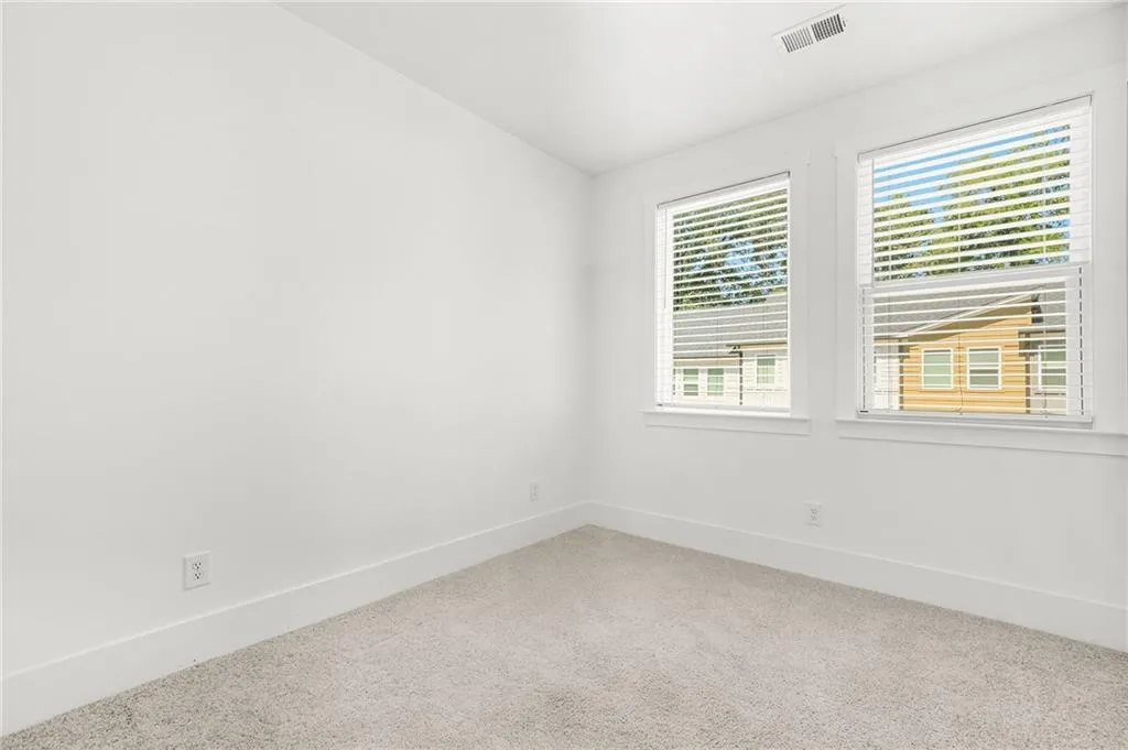 Second bedroom featuring baseboards and vaulted ceiling