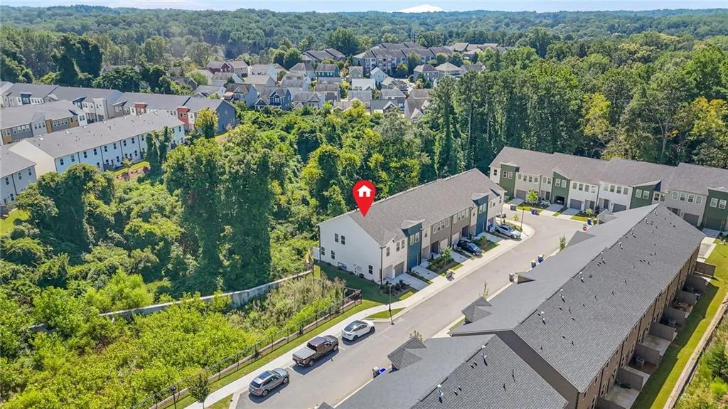 Aerial perspective of suburban area featuring a heavily wooded area