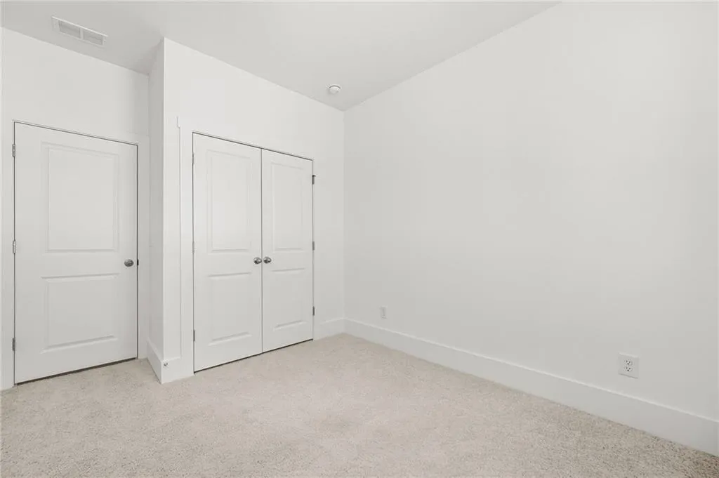 Second bedroom featuring light carpet and a closet