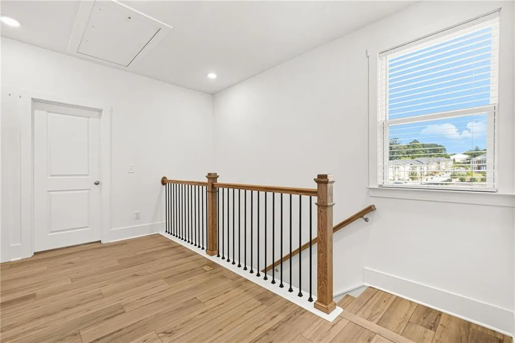 Staircase with wood finished floors, recessed lighting, and attic access