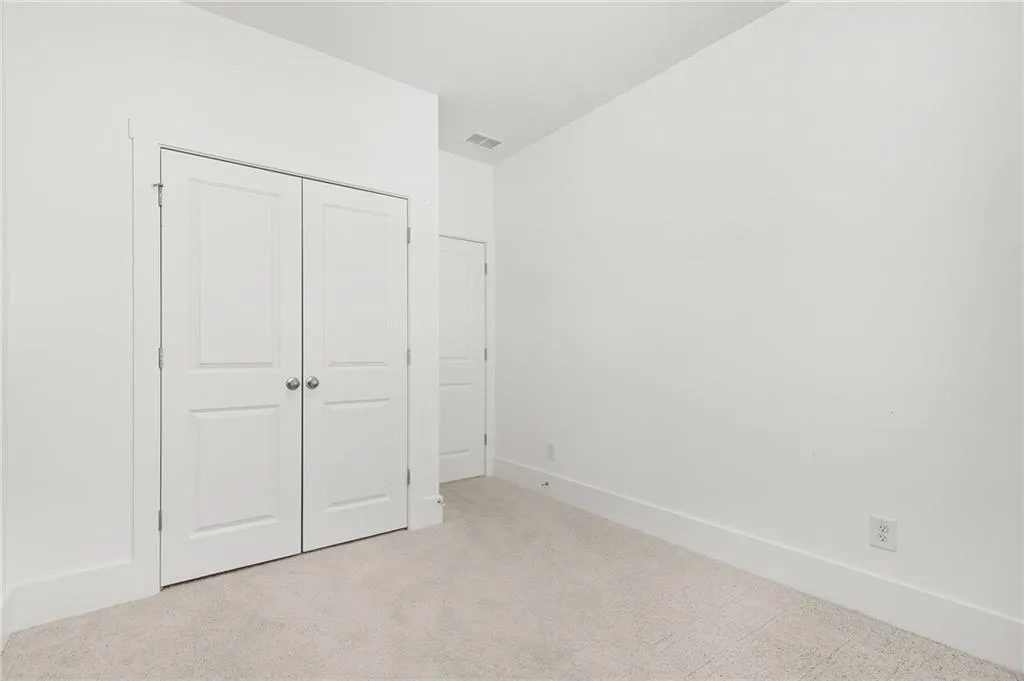 Third bedroom  featuring light carpet and a closet