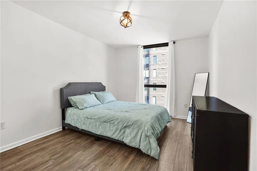 Bedroom featuring wood finished floors and floor to ceiling windows