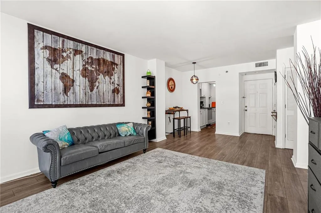 Living room featuring dark wood-style floors and baseboards