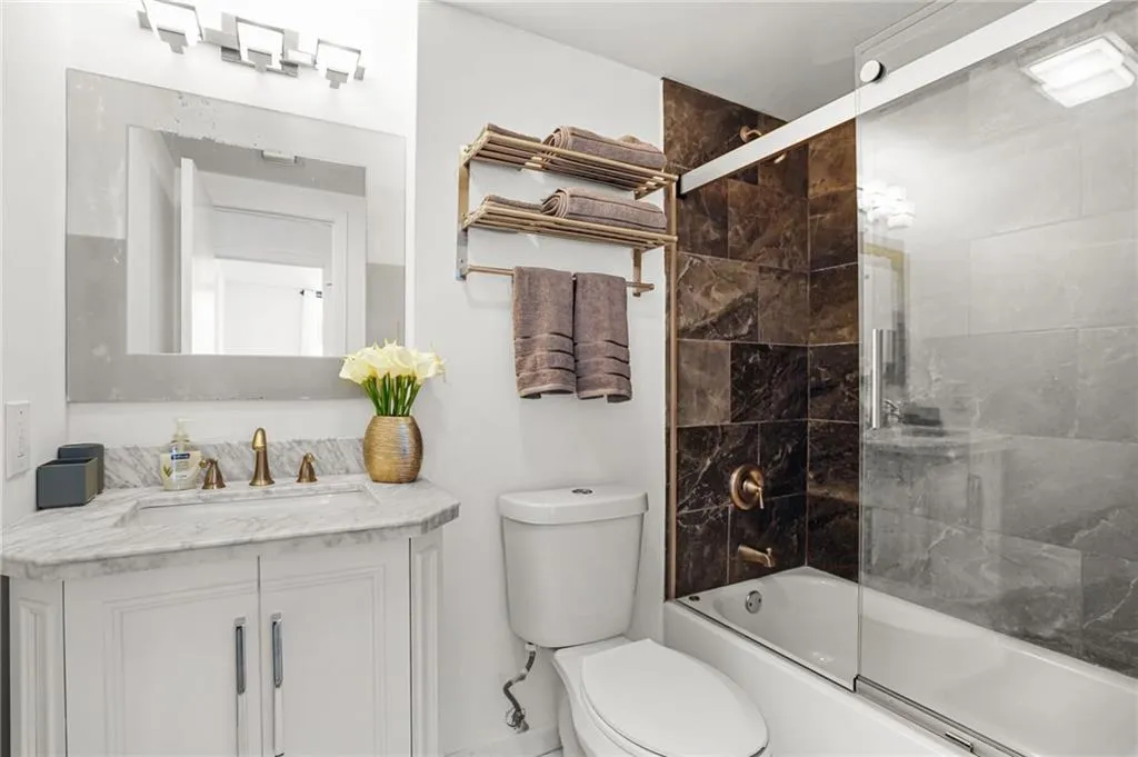 Full bathroom featuring shower / bath combination with glass door and vanity