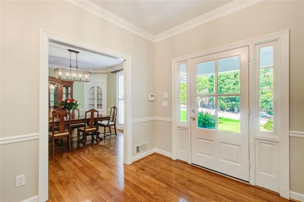 Foyer with  a glass front door and beautiful hardwood flooring. 9 foot ceiling in this home.