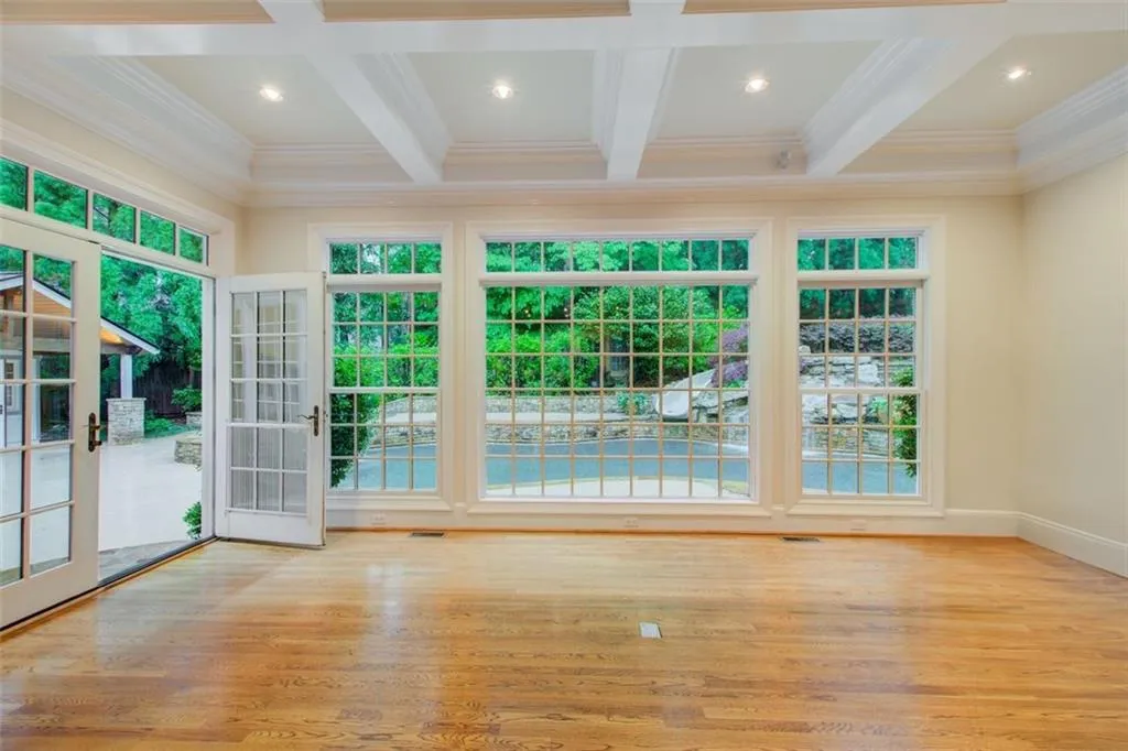This coffered ceiling keeping room is bathed in natural light from floor-to ceiling windows. Just say WOW!