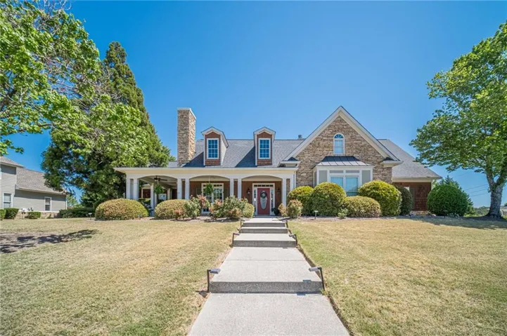 Stone and siding exterior with a covered front porch featuring white columns
