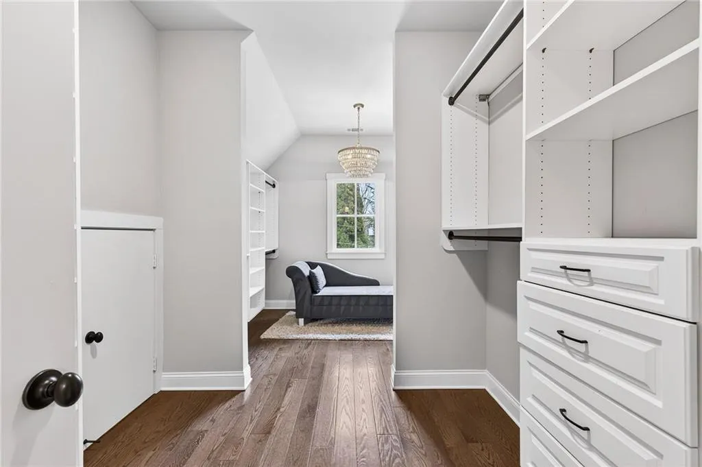 Walk in closet with a chandelier, and extra storage in eaves