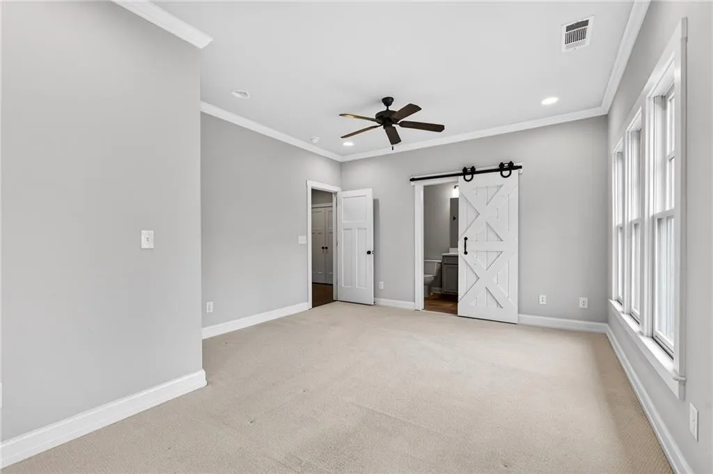 Upper level bedroom with a barn door ensuite bath