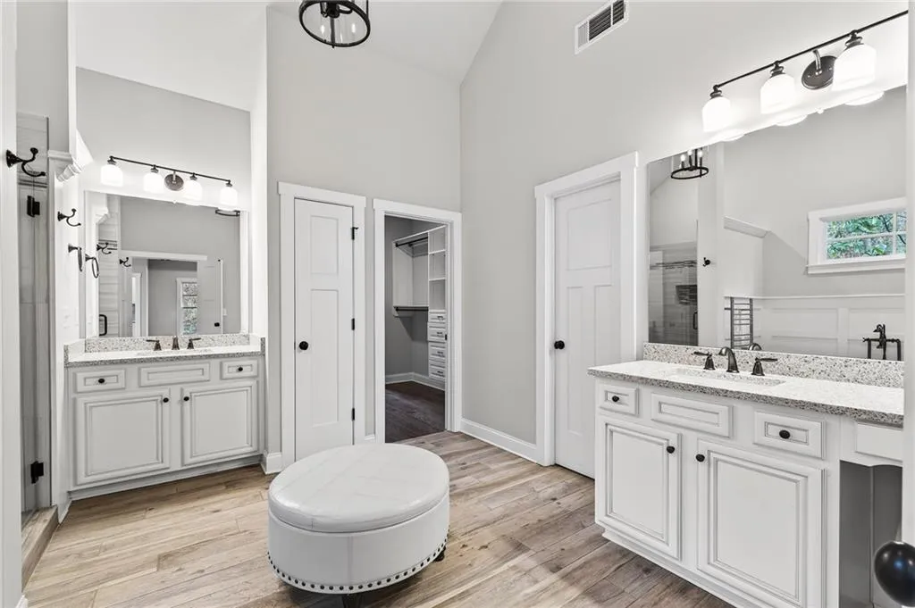 Ensuite bath with dual vanities, soaking tub, water closet, linen closet, a walk in closet with extra eaves storage