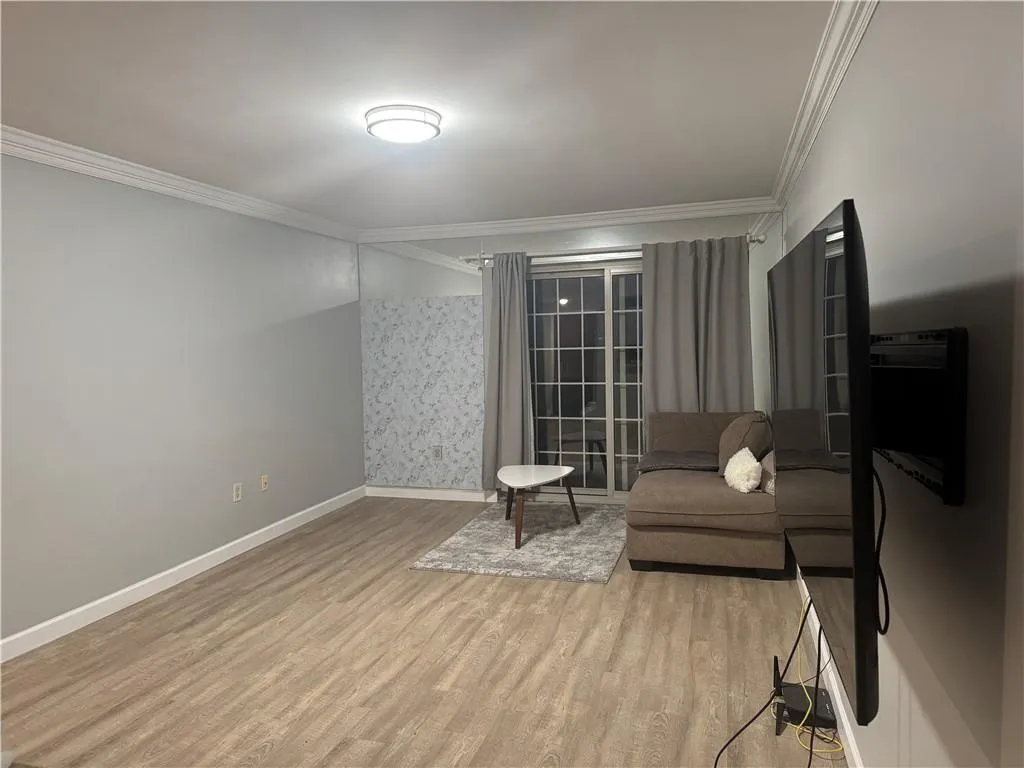 Sitting room featuring ornamental molding and light wood-style floors