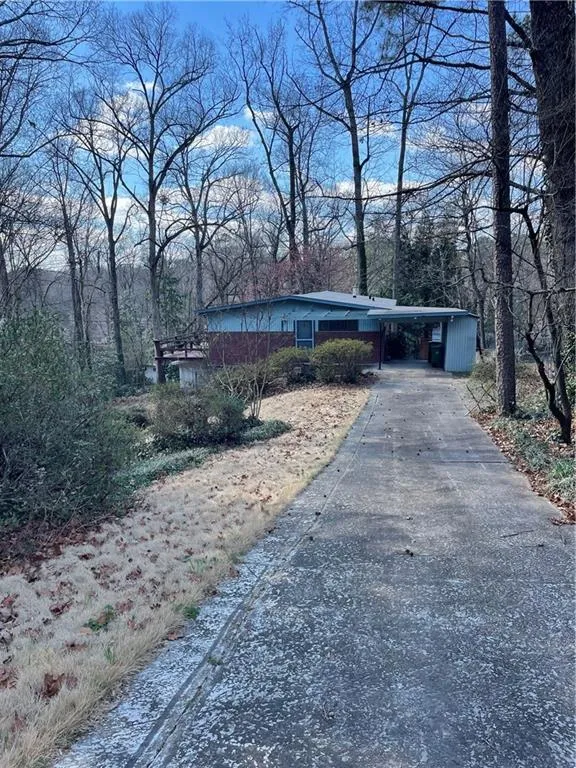 View of front of house with a carport and driveway