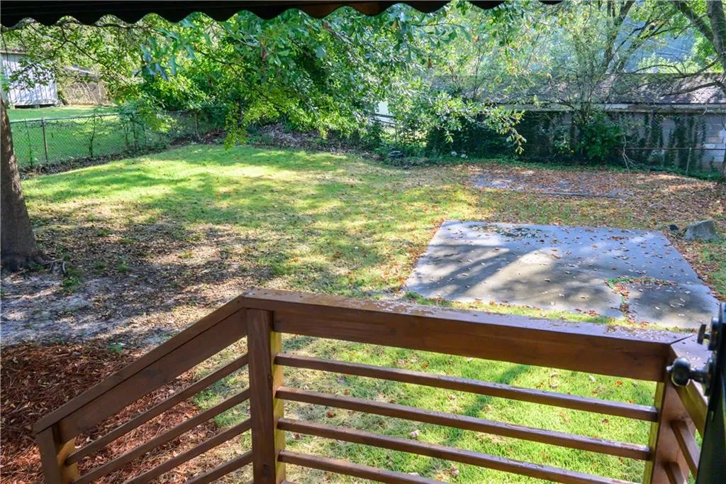 Fenced backyard with a balcony