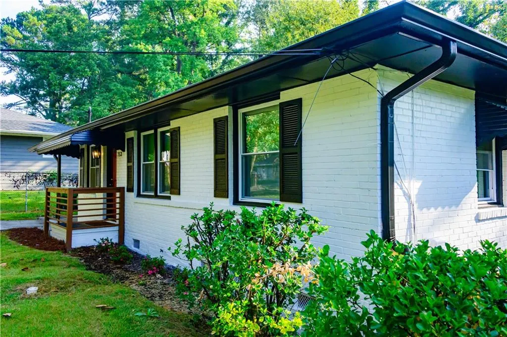 View of home's exterior with brick siding, covered porch, and crawl space