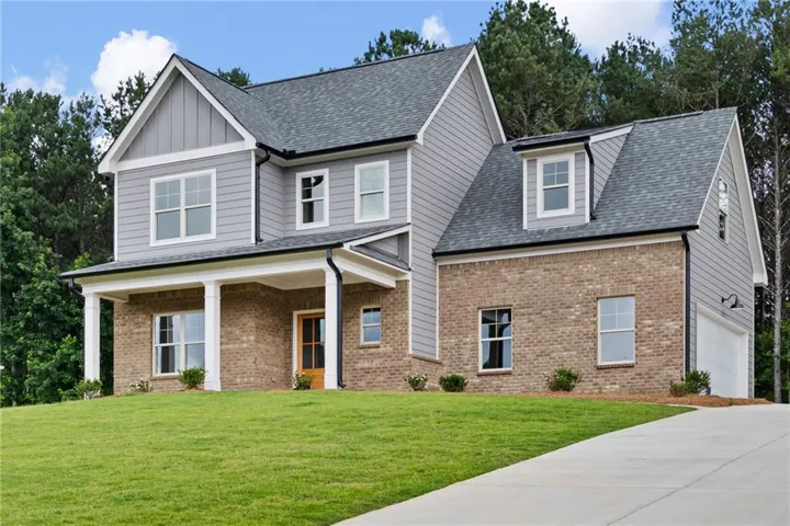 Two-story residence featuring light gray siding and brick veneer