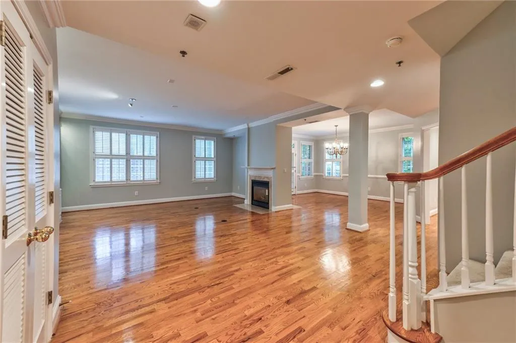 Living room hardwood flooring, a high end fireplace, and ornamental molding