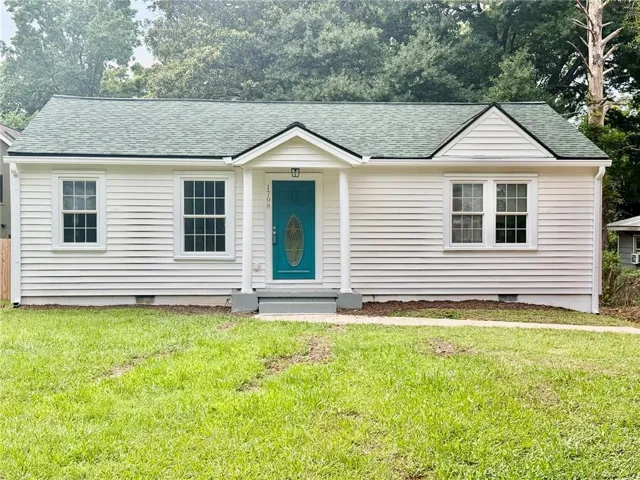 White horizontal siding exterior with a vibrant teal front door featuring an oval glass insert