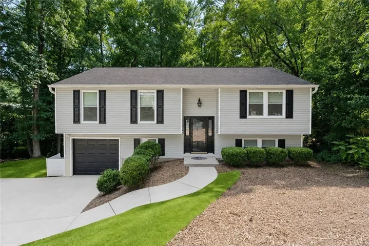 Exterior with light-colored siding, black shutters, and a dark asphalt shingle roof