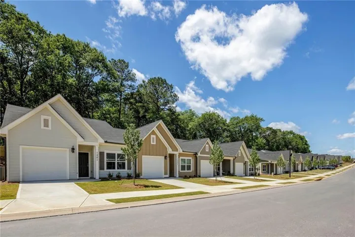 Single story home with concrete driveway, a garage, board and batten siding, and a residential view