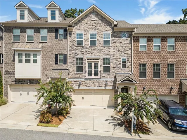 Stone and brick exterior with multiple window styles, dormer windows, and a covered entry