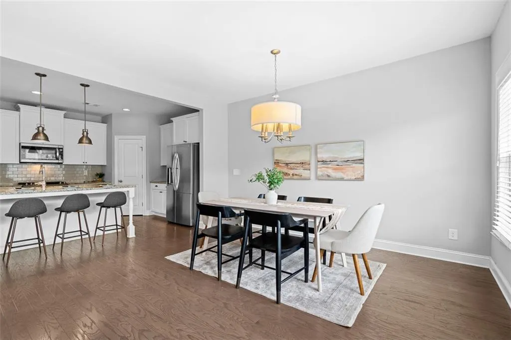 Dining area with dark wood-style flooring, plenty of natural light, a chandelier, and recessed lighting