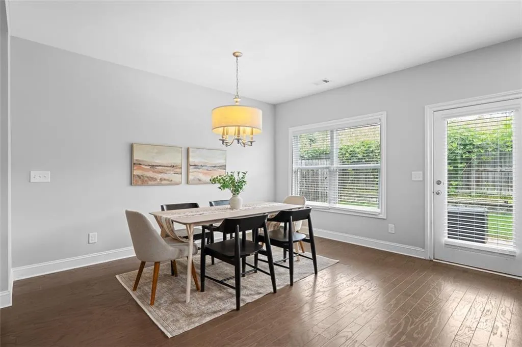 Dining space with dark wood-style flooring and a chandelier