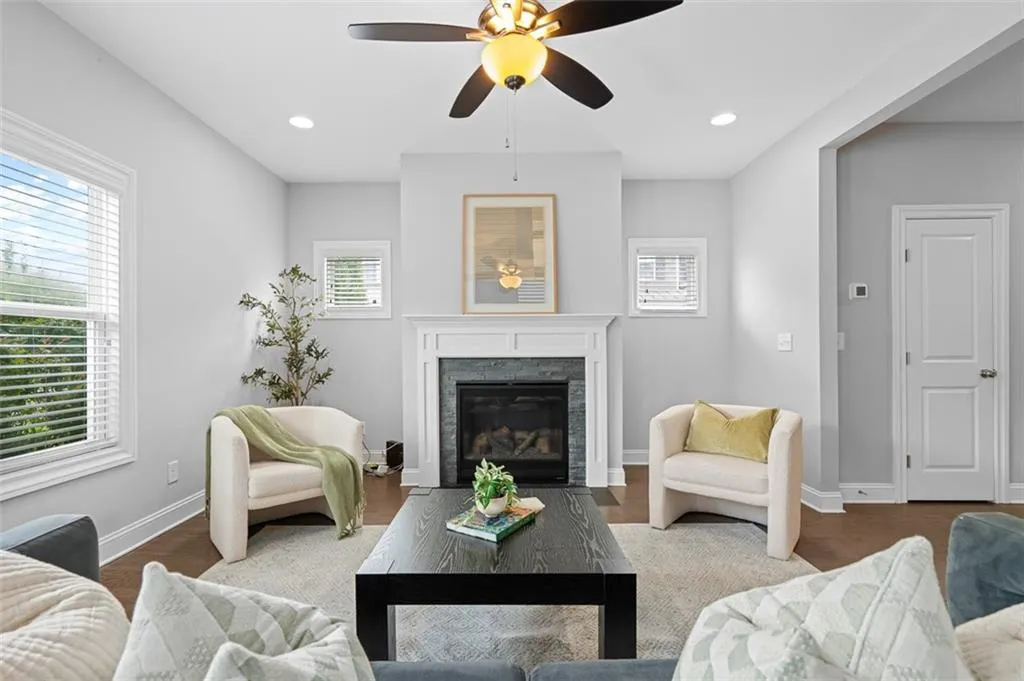 Living room with plenty of natural light, a ceiling fan, a fireplace, wood finished floors, and recessed lighting