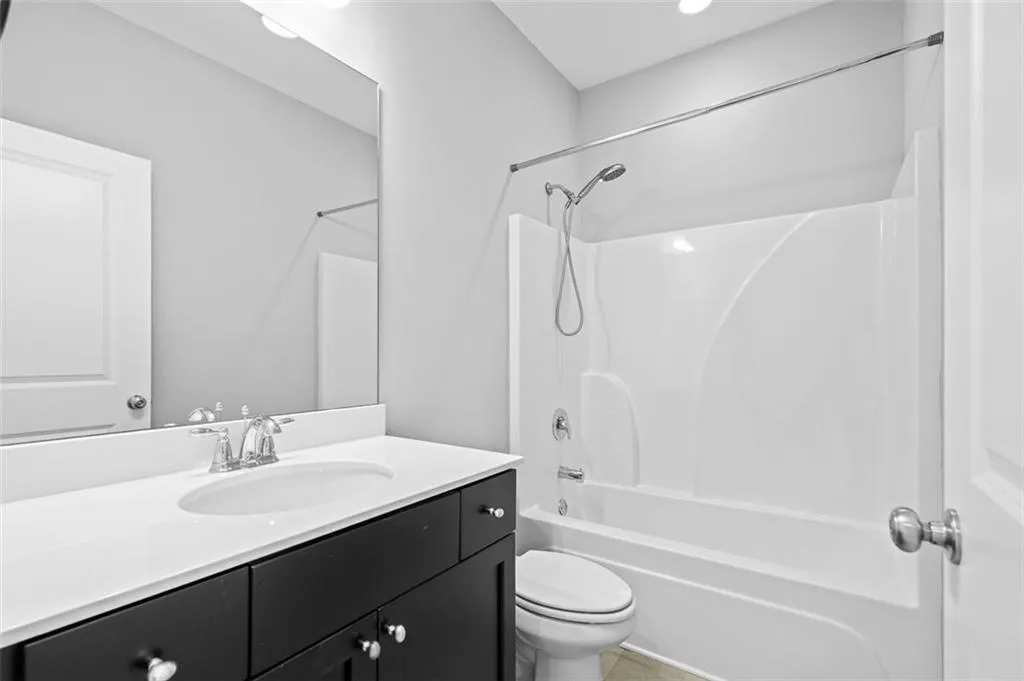 Bathroom featuring vanity, bathtub / shower combination, and tile patterned floors