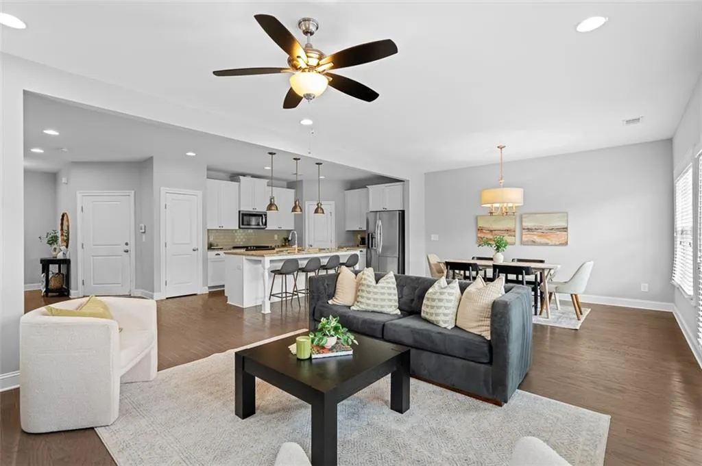 Living area with dark wood-style flooring, recessed lighting, and a ceiling fan