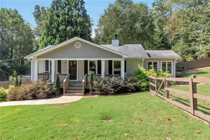 Craftsman-style exterior with a covered porch, wood railing, and dark shutters