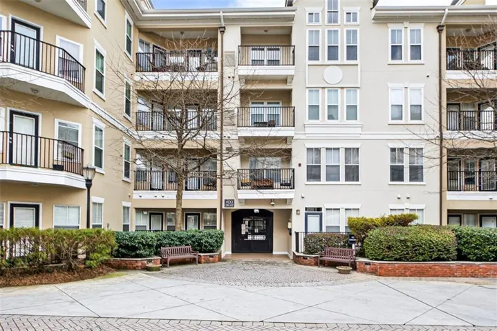 Multi-story building featuring a stucco exterior with decorative trim and multiple private balconies with black iron railings