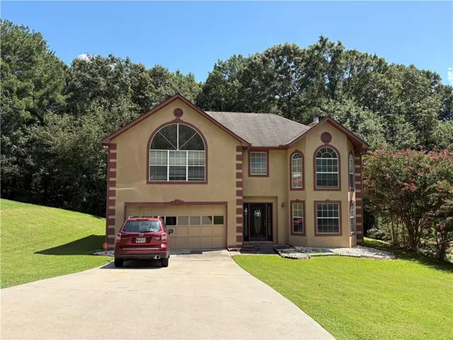 Two-story stucco exterior with decorative trim, arched window accents, and an attached two-car garage