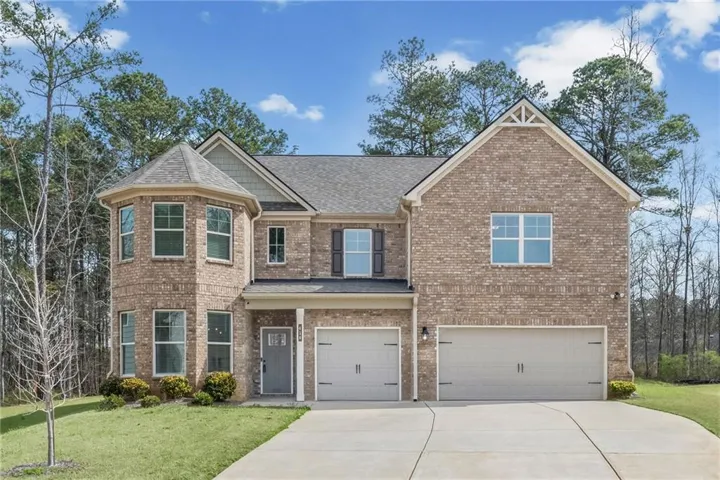 Craftsman house featuring an attached garage, brick siding, a front yard, concrete driveway, and a shingled roof